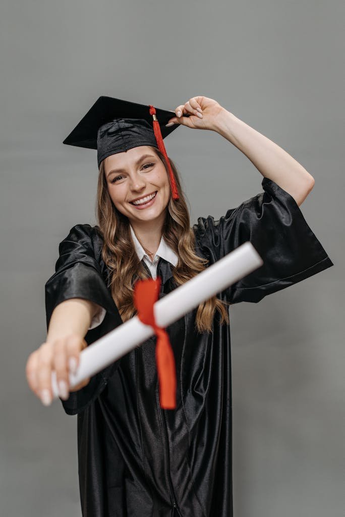 Photo of Woman in Academic Dress Holding Diploma